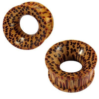 Load image into Gallery viewer, The hand-carved Holztunnel Kokosholz Tribal Holz Tunnel Plugs feature a light brown base with red-brown and black dots and stripes, circular shape, flared edges, and a hollow center.
