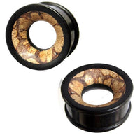 Load image into Gallery viewer, A pair of black circular Holztunnel Eisenholz plugs with open centers, featuring a hand-carved brown patterned Antikholzinlay inspired by Tribal Holz Tunnel designs.
