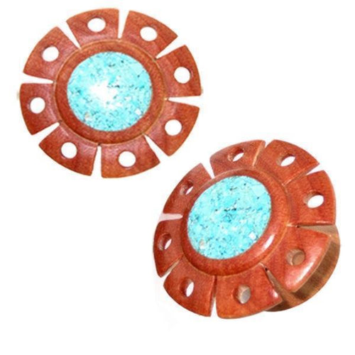 A pair of hand-carved Holzplug Rosenholz hellbraun Blume earrings, inspired by Tribal Holz Plug Tunnel design, features a turquoise inlay center and a light brown floral border.