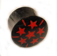 Load image into Gallery viewer, The Horn Plug schwarz rot Sterne Büffelhorn double flared features a black cylindrical design with six red stars and small red lines in a circle on the top, shown on a white background.
