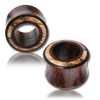 Cargar imagen en el visor de la galería, Two round Tamarinden Holz Flesh Tunnel Plugs in brown and light tones are shown, one upright and one lying down. These organic Ohrschmuck pieces rest on a white surface with a faint reflection beneath.
