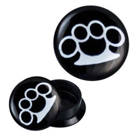 Load image into Gallery viewer, Two black Schraub Plug Acryl Schlagring Plugs feature a white brass knuckles design; one plug is closed, the other open to show the threaded interior.

