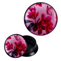 Load image into Gallery viewer, A pair of Schraub Plug Acryl Blumen Schmetterling Blätter rosa pink Ohrschmuck Piercing, featuring black plugs with a pink front decorated with red flowers, green leaves, and a faint butterfly—shown open to reveal the hollow interior.
