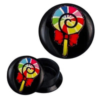 Load image into Gallery viewer, The Schraub Plug Acryl bunter Lolli Schleife Schnecke Piercing Ohrschmuck features a black base with a spiral lollipop in red, yellow, green, blue, and a red bow, shown both closed and with the top removed.
