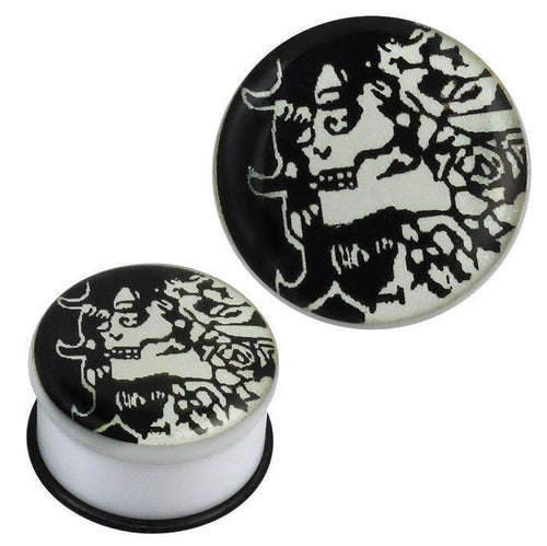 The single flared Plug Acryl Gummiring weiß schwarz Hexe Piercing Ohrschmuck features a black and white abstract witch face with flowing hair on its circular surface, secured by a black rubber ring.