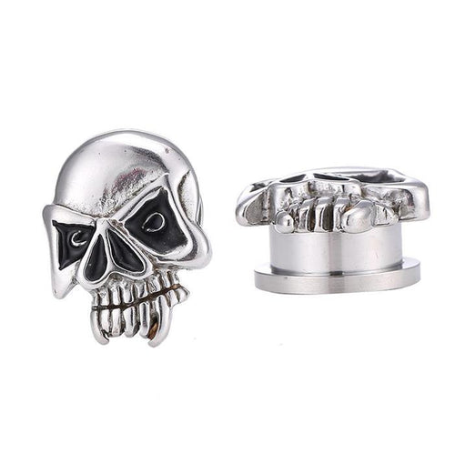 Two Edelstahl Tunnel Plug silber Farben Totenkopf Gebiss Skull Schraubplug dünn schwarz: metallic skull plugs with black accents, showing detailed teeth and cheekbones—one forward-facing, one showing top and side views.