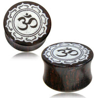 Load image into Gallery viewer, A pair of dark brown &quot;Holz Plug Tamarinde Bone Inlay Om&quot; plugs with an oriental carved design, featuring a white Om symbol (ॐ) at the center, bordered by an ornate pattern.

