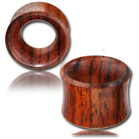 Load image into Gallery viewer, A pair of Blutholz Flesh Tunnel rötlich handmade double flared ear gauges, featuring polished reddish-brown wood with visible grain—one upright and one on its side—highlighting the elegant hollow tunnel design for organic piercing enthusiasts.
