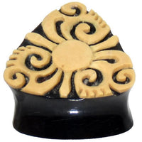 Cargar imagen en el visor de la galería, A black triangular Horn Plug Bio Kokos Schale Dreieck Tunnel with beige tribal floral and swirl carvings—an organic expander perfect as a unique earring or piercing inspired by Tribal Muster.
