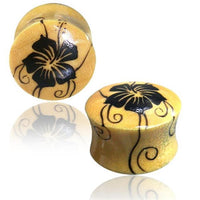 Load image into Gallery viewer, A pair of yellow hand-painted Organic Holz Plug hell Hawaii Blume ear gauges with a glossy finish and black floral design, shown on a white background with reflection.
