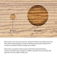 Load image into Gallery viewer, Two circles on a wood grain background, labeled 8 mm and 25 mm, show how the pattern of the Flesh ribbed Tunnel Eisenholz Kokosholz schwarz braun changes by size. Text below details pattern visibility in English and German.
