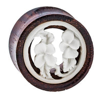 Load image into Gallery viewer, The Holz Plug Tamarindenholz Tunnel features a white bone inlay with a tribal floral design, showcasing two detailed flowers and leaves within the round frame.
