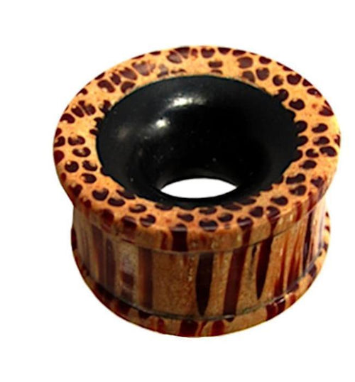 The Flesh ribbed Tunnel Eisenholz Kokosholz schwarz braun is a round, hollow plug with a wide rim and black center, featuring striking brown and tan stripes—perfect for adding bold tribal flair to your look.