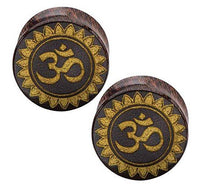 Cargar imagen en el visor de la galería, A pair of hand-carved Tamarind wood plugs, each featuring a gold-painted Om symbol with a laser-engraved floral design, crafted in a tribal organic style.
