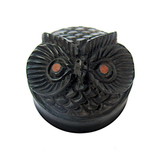 The "Holz Plug Eule schwarz handgeschnitzt braune Augen" is a round, dark wood plug with an owl’s face, detailed feathers, brown eyes, and a small beak—an eye-catching organic Schmuck shown on a white background.