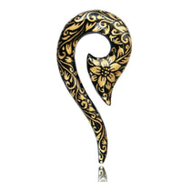 Load image into Gallery viewer, The Piercing Holz Beil Fragezeichen Plug is a black, hand-painted wood earring with gold floral designs, shaped like a question mark—an ornate Blumen Ohrstecker Expander.
