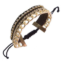 Load image into Gallery viewer, A wide Ibiza Hippie Style Damen Armband aus Kunstleder, Brass und Baumwolle in Gold, 30 cm lang. Features include a multistrand design with adjustable black woven closure and stylish dangling black cords.
