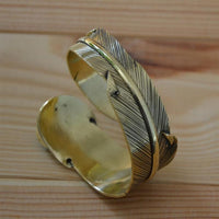 Load image into Gallery viewer, breiter Messing gold Armreif als Feder mit Türkis
