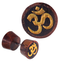 Load image into Gallery viewer, Fake Holz Plug Tamarinde dunkelbraun schwarz Maserungen OM-Zeichen golden Piercing
