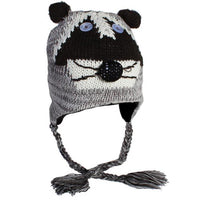 Cargar imagen en el visor de la galería, Die Unisex Tiergesicht Mütze Norwegermütze ist eine gestrickte Waschbär-Mütze mit Knopfaugen, schwarzer Nase, schwarz-weißen Mustern, Ohrenklappen mit Zopfbändern und kleinen Ohren oben.
