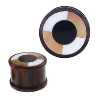 Load image into Gallery viewer, Two brown wooden plugs with a wide rim, black resin center, and alternating white and tan Perlmutt inlays form unique Tribal Holz Plug Ohrschmuck (Tunnel Expander Organic).
