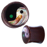 Load image into Gallery viewer, The Sonoholz Plug Yin Yang Inlay Paua Abalone Resin schwarz is a cylindrical black tunnel expander featuring a tribal Yin Yang inlay with iridescent abalone and a green dot, shown from the front and angled views.
