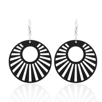 Load image into Gallery viewer, A pair of 5 cm round Holzohrringe, featuring colorful sunburst circle cutouts and nickel-free silver hooks. These organic Damen Ohrhänger showcase alternating black and white radial segments for a striking look.

