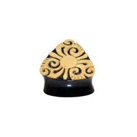 Cargar imagen en el visor de la galería, The Horn Plug Bio Kokos Schale Dreieck Tunnel in black features a raised beige abstract swirl pattern with a central circle—ideal as an organic expander or unique tribal-style piercing earring.
