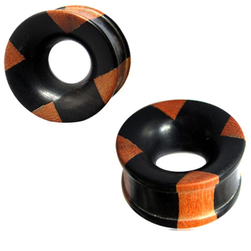 Hand-carved Holztunnel plugs made of black Eisenholz and brown Teakholz with a cross pattern, hollow center, and flared edges—a bold Tribal Holz Tunnel design.