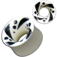 Load image into Gallery viewer, The Tribal Bone Tunnel Punkte Streifen Muster is a hand-carved organic expander plug, white with black swirls and dots on the flared edge, shown from side and top views.
