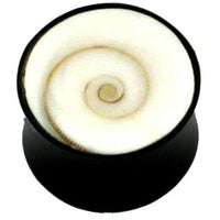 Cargar imagen en el visor de la galería, A round black Tribal Horn Plug Shiva Auge, an organic expander with a white spiral shell design, is shown from above on a plain white background.
