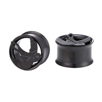 Load image into Gallery viewer, Two Tunnel Plug Edelstahl Schraubplug dünn schwarz plugs, each featuring a raised Friedenstaube motif with outstretched wings. One plug stands upright while the other lies on its side.
