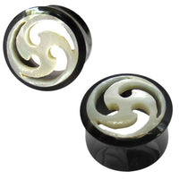 Load image into Gallery viewer, A pair of double flared round black Horn Plug Tunnels featuring a white Perlmutt Tomoe Inlay, shown from top and angled views. Ideal for tribal piercing styles.
