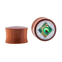Load image into Gallery viewer, One Organic Sabaholz Plug features Paua Abalone Perlmutt inlay with a white ornate frame, while the other side shows the plain, hand-carved wood of the eckig gerahmt Perlmutt Tunnel Tribal Expander.
