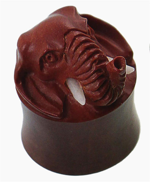 A brown carved wooden plug with a 3D elephant head, detailed ears, trunk, and bone-like tusks—Holz Plug braun Elefant Bone Stoßzähne plastisch Tunnel Tribal Expander Organic.