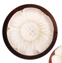 Load image into Gallery viewer, The Sonoholz Plug Perlmutt Blume handgeschnitzt schillernd features a round carved white button with a shimmering flower pattern and textured center, set in a dark brown circular wooden border.
