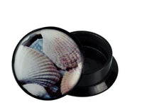 Load image into Gallery viewer, A round black Schraub Plug Acryl with a white seashell photo on the lid, partially open to reveal its empty interior. Ideal as Muschel Piercing Ohrschmuck.
