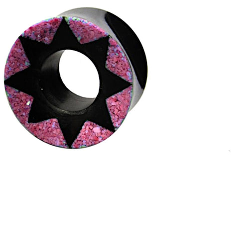The Horn Tunnel schwarz Stern Muster pink is a hand-carved plug with a black star design in the center and a pink textured outer ring, displayed on a white background.