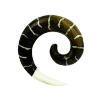 Cargar imagen en el visor de la galería, The Tribal Holz Piercing Expander features a dark brown spiral design with white bone inlay and a pointed bone tip, crafted from hand-carved Tamarindholz, making it a unique Plug Tunnel accessory.
