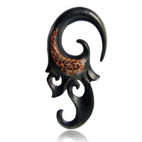 Load image into Gallery viewer, The Holz Piercing schwarz Eizenholz Spirale features a curved black spiral with ornate details and a Kokosholz Inlay showing a brown, spotted animal print, giving it a bold ethnic look ideal for unique tribal style.
