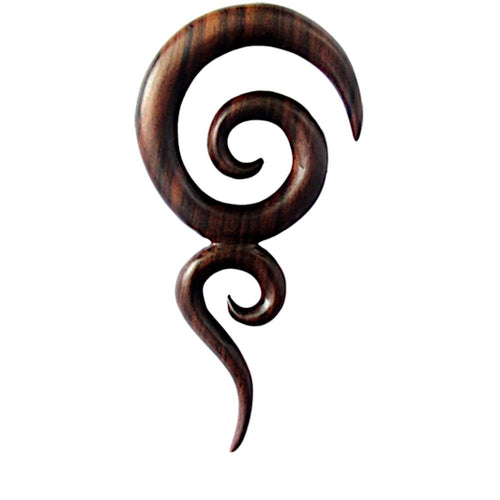 The Sonoholz lang Tribal Piercing Holz zwei Spiralen handmade is a dark wooden earring with smooth, curving spirals and pointed ends, making it a striking accessory set against a white background.