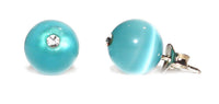 Load image into Gallery viewer, A pair of Ohrstecker Katzenauge mit hellblauer Perle, weißem Glitzer-Stein und 925er Sterling Silber – stilvolle Steinohrstecker auf weißem Hintergrund.
