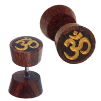 Load image into Gallery viewer, Fake Holz Plug Tamarinde dunkelbraun schwarz Maserungen OM-Zeichen golden Piercing - chic-net.de
